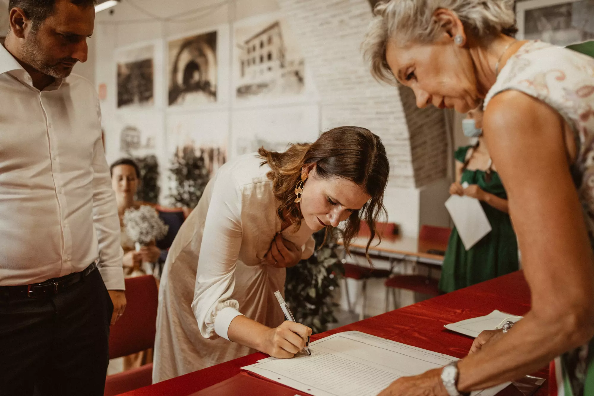 A bride signing a marriage certificate during a civil wedding in Italy.