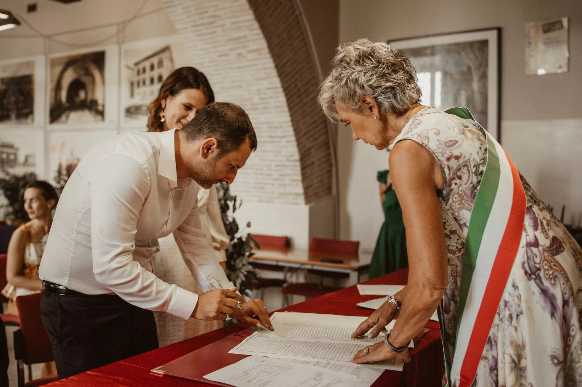 A groom signing a marriage certificate before the Major of the town hall in Italy.