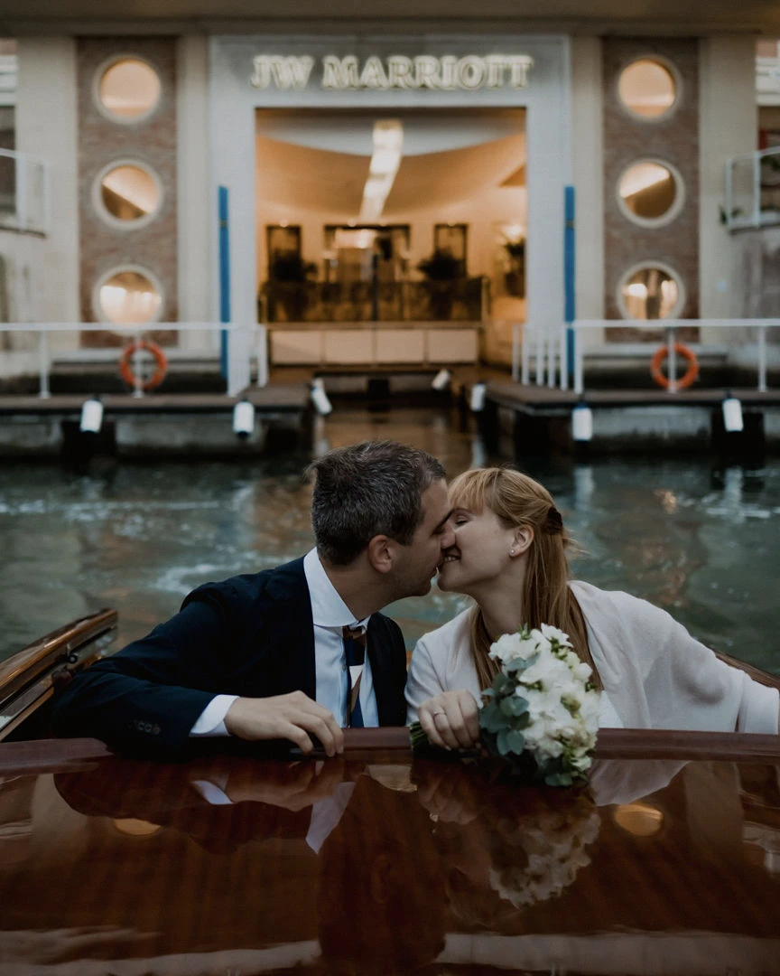 A couple leaving the dock of the Marriot in Venice on a boat.