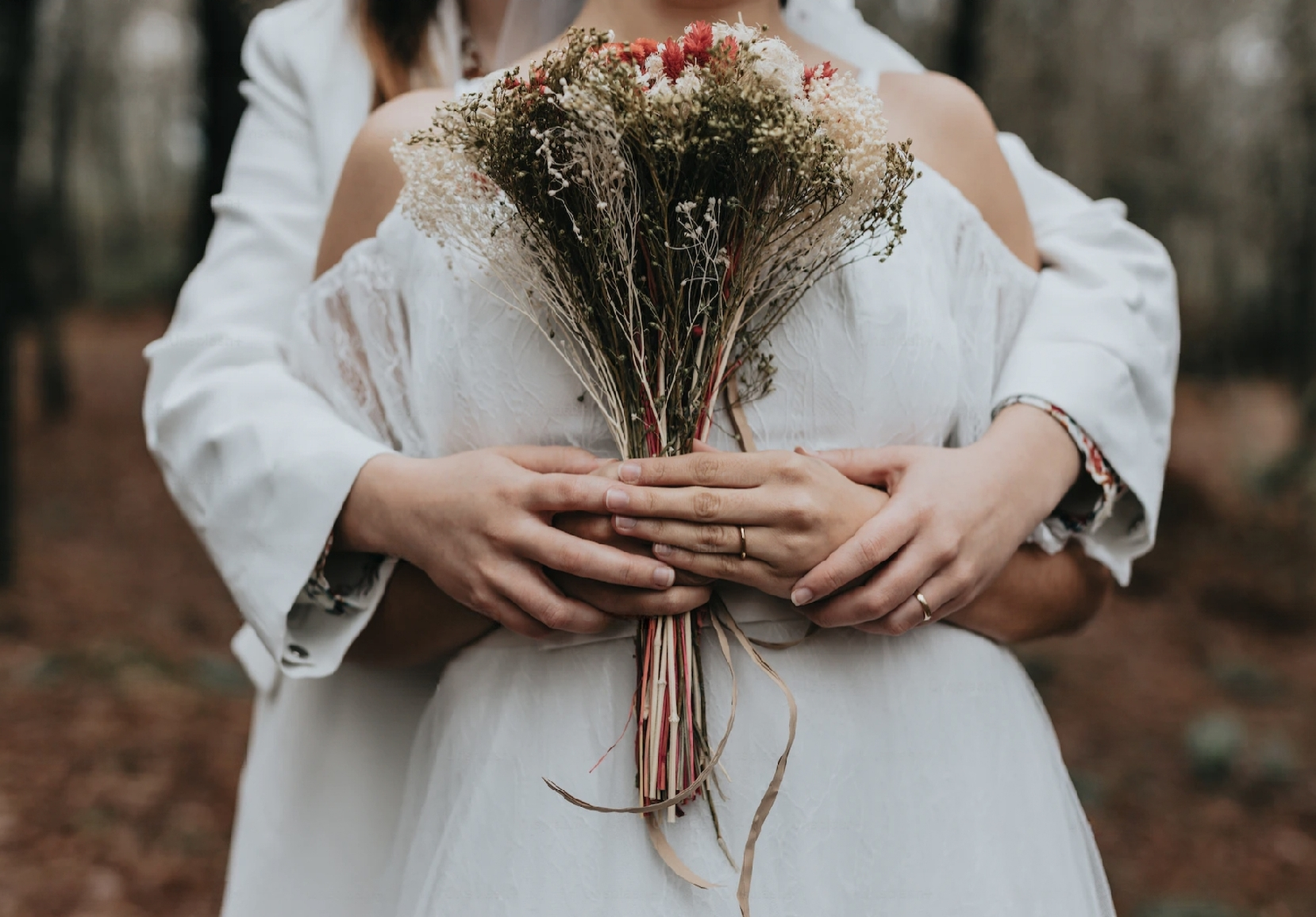 Two ladies hugging each other after a wedding.