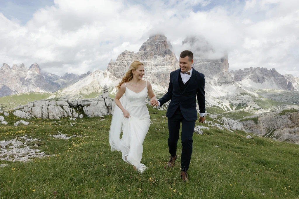 A newlywed couple running together on Cadni di Miusrina.