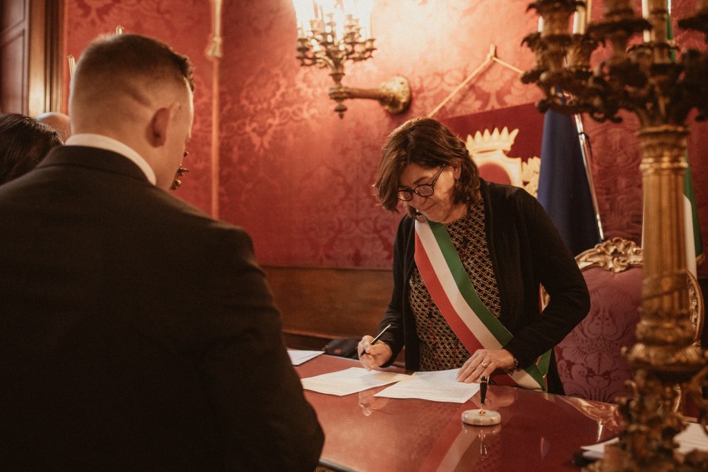 A Mayor of an Italian town hall check the documents of an American citizen.