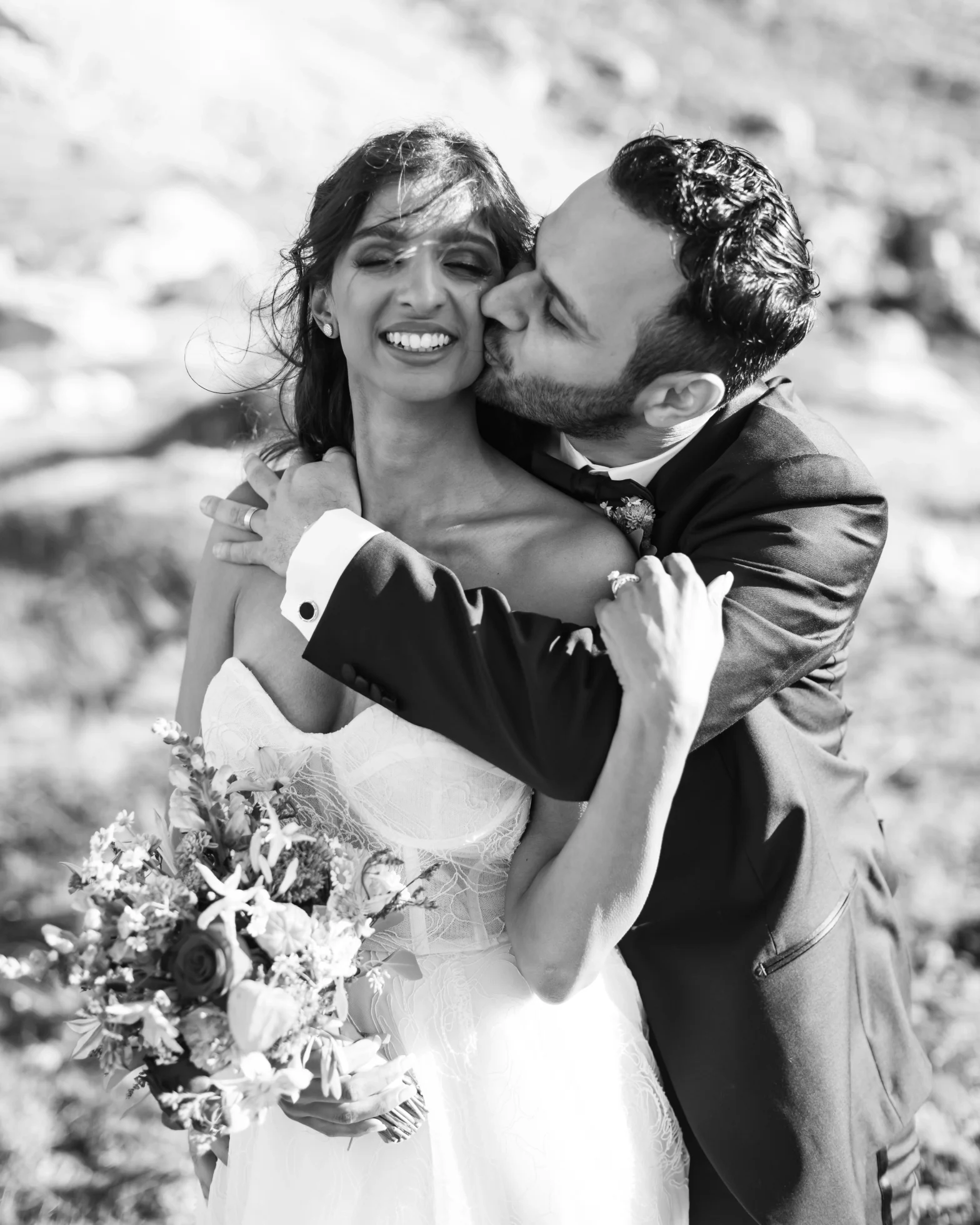 Groom embracing bride from behind after their Dolomites wedding ceremony.